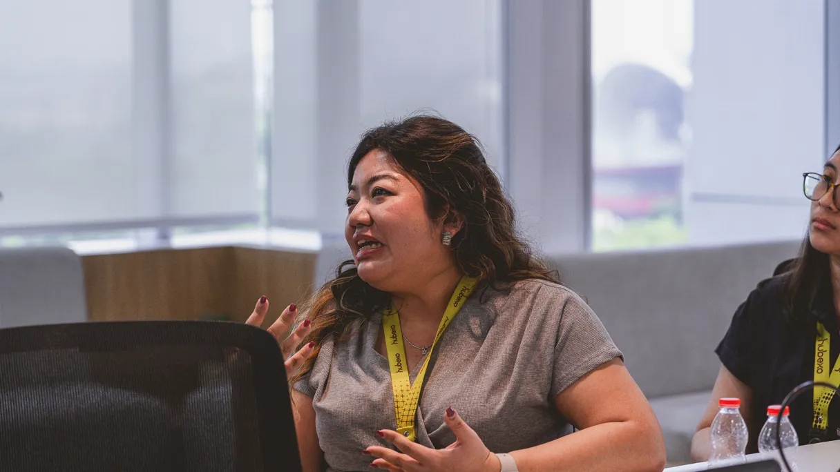 A woman speaking during a meeting with a focused expression