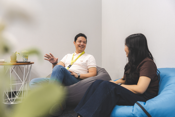 Two people sitting on bean bags engaged in conversation