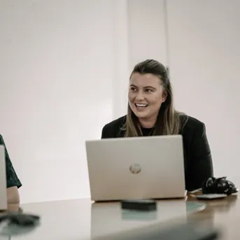 Woman smiling at a laptop during a meeting