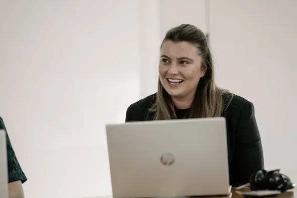 Woman smiling at a laptop during a meeting