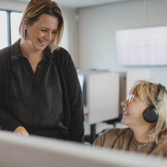 Two women engaged in conversation in an office setting