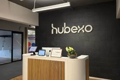 Reception area with a sign for Hubexo and a decorative plant
